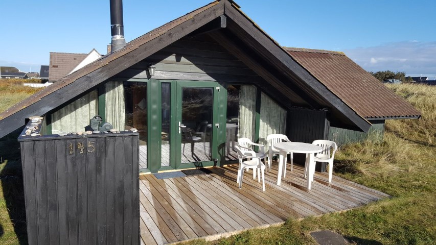 Große windgeschützte Terasse mit Holzkohlegrill und Spielzeug.